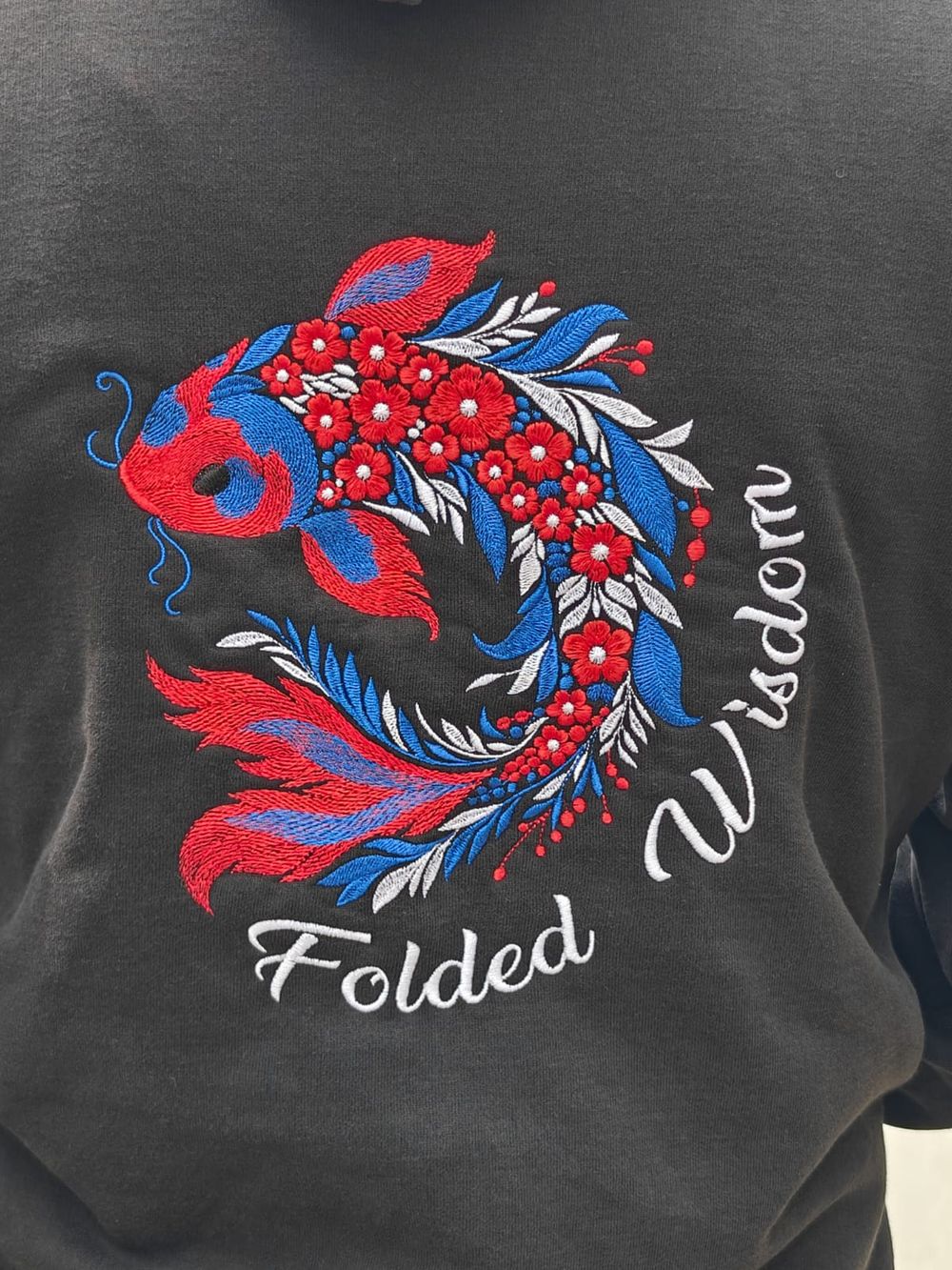 Close-up of the koi and lettering embroidery