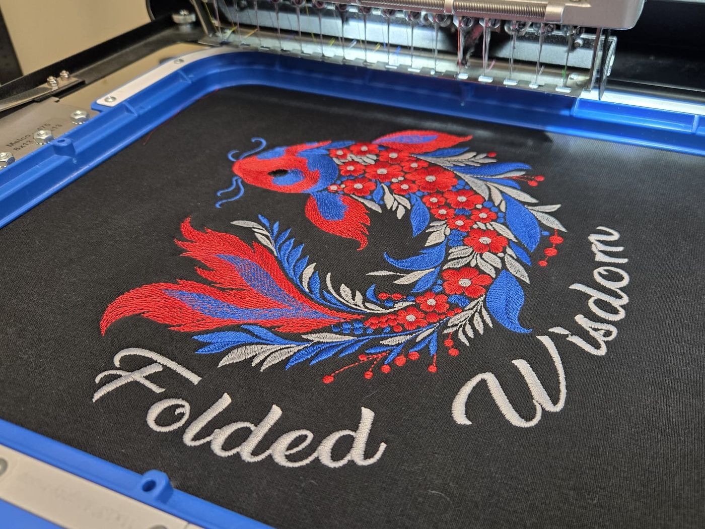 The koi design being stitched on our embroidery machine